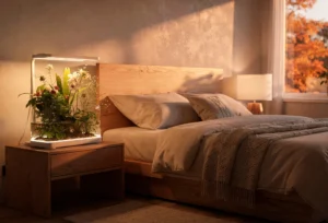 Sistema de hidroponia moderno com iluminação LED sobre mesa de cabeceira de madeira em quarto com design biofílico.